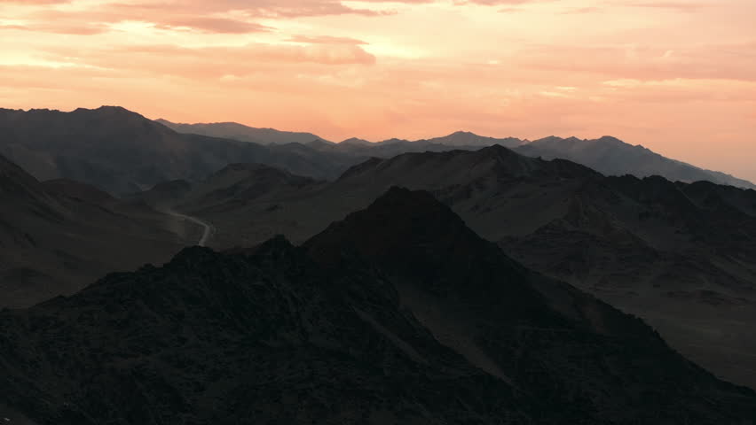 Epic aerial views of the Altai mountains at sunset, showcasing dramatic peaks and vast cinematic landscapes in Mongolia