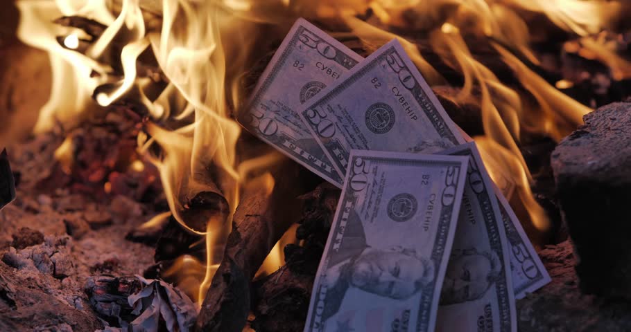 American currency surrounded by fire. Concept of burning money.