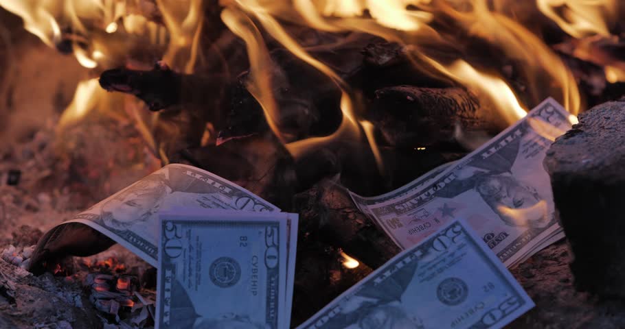American currency surrounded by fire. Concept of burning money.