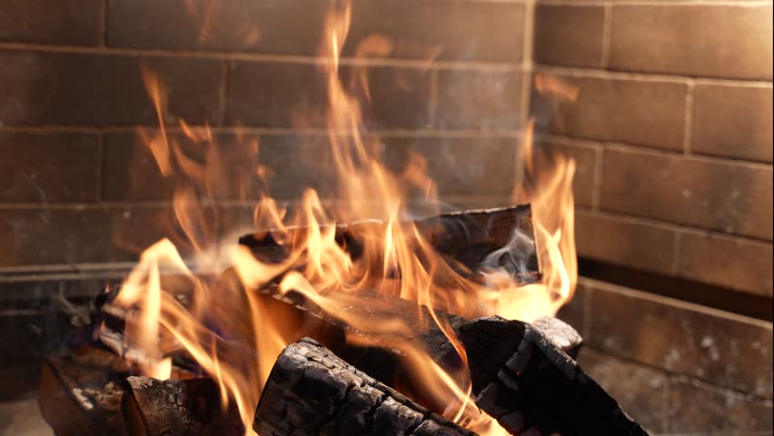 fire burns in a wood-burning stove. fireplace on the background of a stone wall. winter
