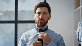 Professional worker wearing tie at house closeup. Confident director correcting shirt preparing for work at large modern wardrobe. Handsome bearded man looking mirror adjusting collar alone indoors - Powered by Shutterstock - Get 15% off with code: PIKWIZARD15