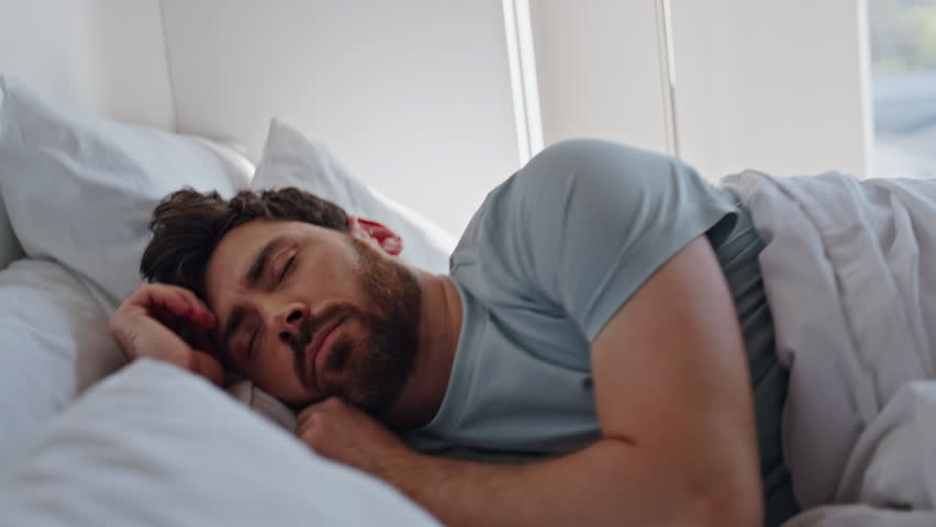 Stressed man awaking early morning. Tired guy oversleep looking smartphone missed alarm. Anxious brunette waking up check mobile phone. Handsome frustrated male going back sleep at light apartment  - Powered by Shutterstock - Get 15% off with code: PIKWIZARD15