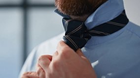 Closeup man wearing tie preparing for work at home. Bearded businessman hands getting better shirt indoors. Unknown groom standing before wedding ceremony at modern apartment. Official moment concept - Powered by Shutterstock - Get 15% off with code: PIKWIZARD15