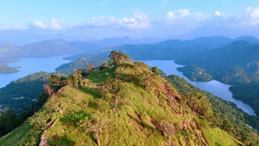 Top of the high rock covered with grass and some trees. Picturesque mountains and lakes of Sri Lanka from aerial perspective.