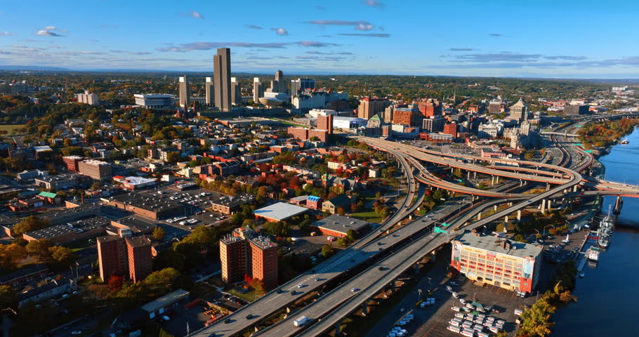 Interchange with moving cars on the river waterfront. Aerial perspective on Albany, New York State, USA on sunny day.