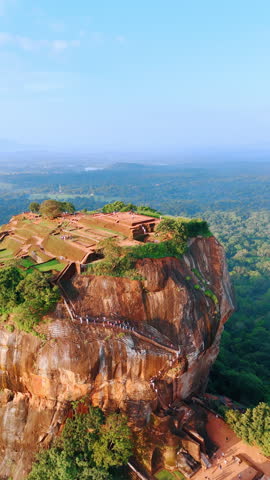Tourists go up by the stairs to Sigiriya in Sri Lanka. Ancient rock fortress from top perspective. Vertical video.