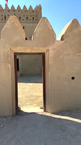 Vertical screen:Arabic fort stands resilient in vast desert, highlighting Arabic design principles. Fort structure reflects traditional craftsmanship, blending with the desert landscape.