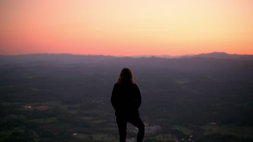 Silhouette of Person Embracing Sunset at Buffalo Mountain Park person with arms outstretched standing on hilltop overlooking stunning sunset Buffalo Mountain Park moment of freedom serenity in nature