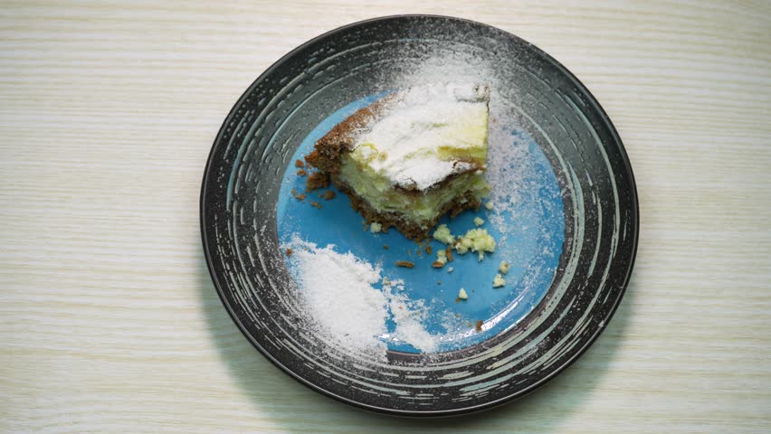 A piece of homemade chocolate cheesecake on a plate with fork. Stop motion the process of eating
