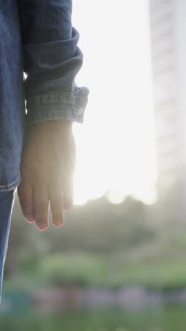 Vertical close up of unrecognizable mature couple holding hands standing outdoor. Anonymous elder tourist adult, pensioner people enjoying their retiree vacation. Relationship and travel concept. 