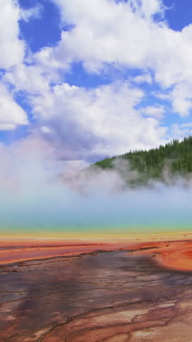 A captivating and vibrant view of Yellowstone National Park that showcases its colorful thermal features and presents a captivating misty atmosphere that invites exploration and adventure