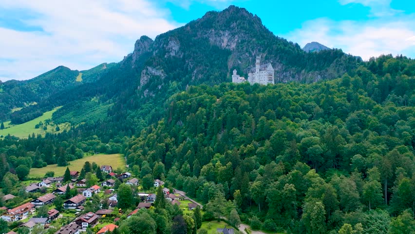 A view of Neuschwanstein Castle,  a 19th-century fairy-tale-like palace perched on a rugged hill above the village of Hohenschwangau in southwest Bavaria, Germany