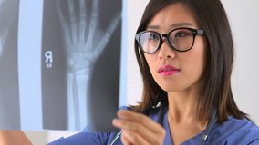Asian woman doctor examining x-ray - Powered by Shutterstock - Get 15% off with code: PIKWIZARD15