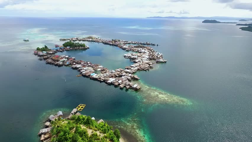 Togean islands, central sulawesi, Indonesia - September 2017: beautyful aerial view of sea gypsy houses "bajau trible village". natural blue water, white sand and coral reefs surround their homes