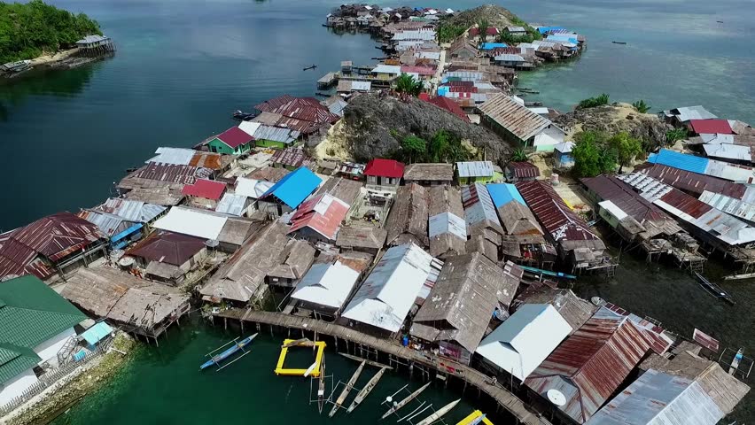 Togean islands, central sulawesi, Indonesia - September 2017: beautyful aerial view of sea gypsy houses "bajau trible village". natural blue water, white sand and coral reefs surround their homes