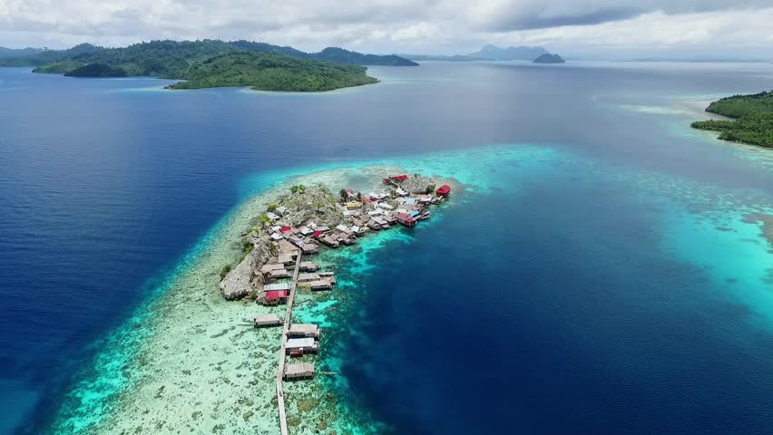 Togean island, central sulawesi, Indonesia - September 2017: beautyful aerial view of sea gypsy houses "bajau trible village". natural blue water, white sand and coral reefs surround their homes