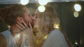 A couple is playfully untangling fairy lights while chatting and laughing. They are excited to transform their room into a warm and inviting space filled with soft lighting. - Powered by Shutterstock - Get 15% off with code: PIKWIZARD15