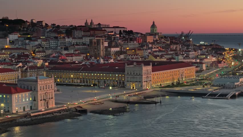 Aerial view of Lisbon, Portugal before sunrise. Epic morning tele shot of Lisbon city with Commerce Square, National Pantheon of Portugal and old city. Red morning sky at background