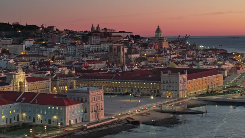 Aerial view of Lisbon, Portugal before sunrise. Epic morning tele shot of Lisbon city with Commerce Square, National Pantheon of Portugal and old city. Red morning sky at background