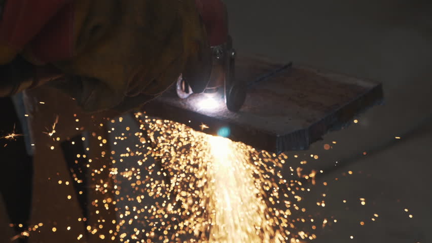 A craftsman is working with a metal sheet using a cutting tool. Sparks fly in different directions, creating a dynamic and intense work atmosphere.