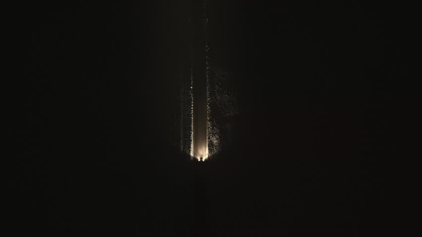 Car traveling along snowy lane at night aerial top down view. Quiet and eerie road in countryside. Vehicle riding on rural road drone tracking shot