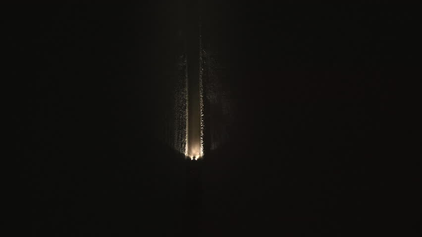 Car traveling along snowy lane at night aerial top down view. Quiet and eerie road in countryside. Vehicle riding on rural road drone tracking shot