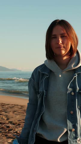 Portrait of young woman holding trash bag with full of plastic bottles waste garbage. Female shaking head and upset about polluted beach with plastic trash. Vertical video