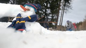 Close-up of a snowman with children playing in the background. Concept: winter and childhood fun. Bright, natural lighting. - Powered by Shutterstock - Get 15% off with code: PIKWIZARD15