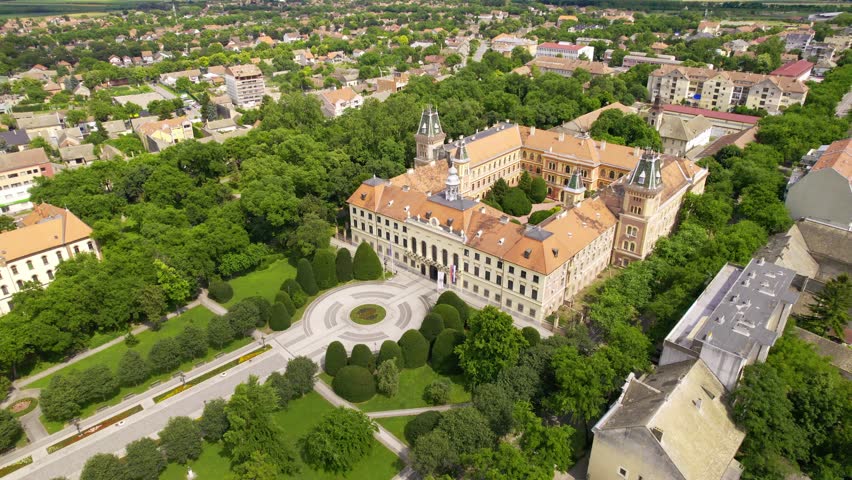Explore a historic building surrounded by lush greenery in a scenic town