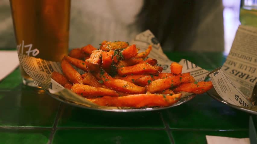 Zooming in on sweet potato fries seasoned with salt and herbs