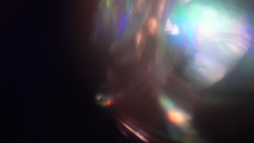 Iridescent colorful light leaks and flares transition on a dark background, creating a beautiful and abstract visual effect