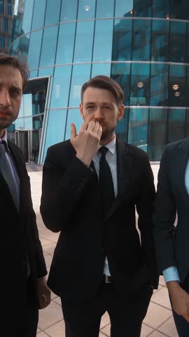 4k. POV. Three Young attractive businesspeople, Businessman and businesswoman, swearing on Your idea. They hate You. Fire and dismiss concept. Formal suits. Teal and orange sunset style. Wide shot