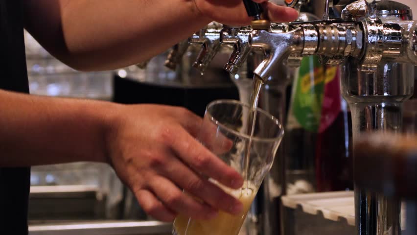 Beer Tap - Bartender Filling Up Glass With A Beer From A Tap Faucet At The Bar. - closeup shot
