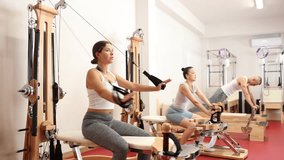 Young woman in sportswear training with straps in pilates studio - Powered by Shutterstock - Get 15% off with code: PIKWIZARD15