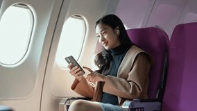 Professional businesswoman wearing wireless earphones listening to music on smartphone while gazing through airplane window during tranquil flight. Embodying modern digital work and travel lifestyle - Powered by Shutterstock - Get 15% off with code: PIKWIZARD15