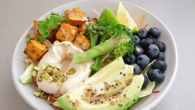Balanced vegan lunch bowl with baked sweet potato, avocado, berries, salad and hummus. Plant Based Diet Concept. - Powered by Shutterstock - Get 15% off with code: PIKWIZARD15