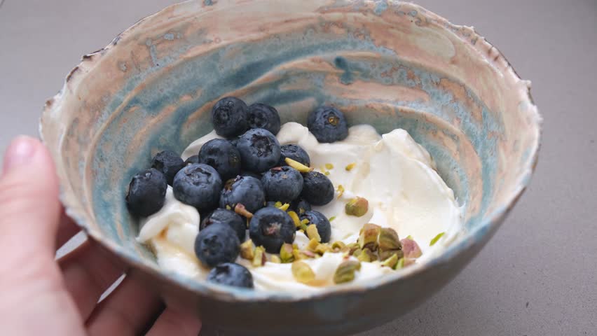 Greek yogurt with blueberries and pistachio bowl. Healthy breakfast concept.