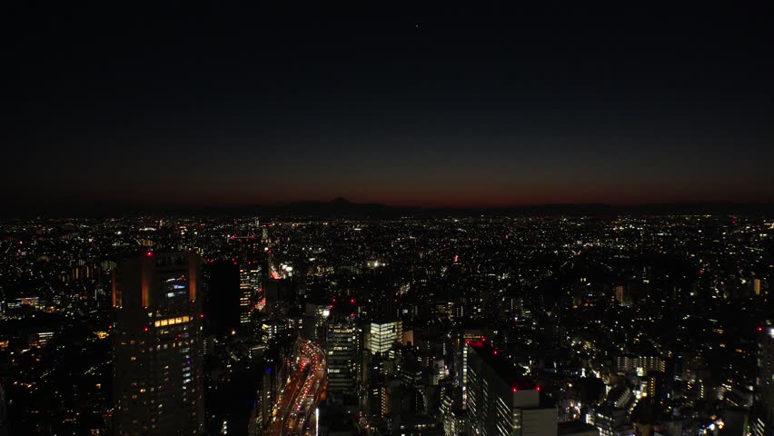 TOKYO, JAPAN : Aerial high angle view of CITYSCAPE of TOKYO at night. View of buildings and street around Shibuya station. Japanese city life and nature concept 4K video.