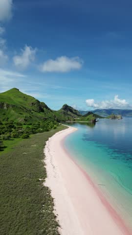 Tropical Island with Sandy Pink Beach with Green Hills and Mountain - Indonesia, Long Beach Komodo Labuan Bajo  - vertical 