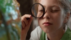 Close up curious Caucasian little girl teen child kid schoolgirl school student pupil using magnifier looking at world globe inspecting map geography lesson exploration studying learning in classroom - Powered by Shutterstock - Get 15% off with code: PIKWIZARD15