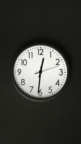 Classic wall clock. Clock face on black background. Time lapse. Time running fast. Analog clock. Wall clock show running time. Vertical video. Close up in 4K, UHD