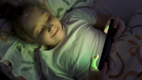 A girl plays an online game on her smartphone at night. Children's dependence on smartphones. Gadget addiction. - Powered by Shutterstock - Get 15% off with code: PIKWIZARD15