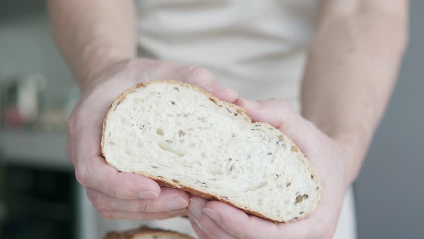 The baker-chef has prepared the bread using the traditional method and tears it into two pieces with his hands.