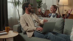 Caucasian man male freelancer user businessman at home couch father working business laptop using computer little girl daughter child kid suddenly jumping surprise scare dad playing laughing family - Powered by Shutterstock - Get 15% off with code: PIKWIZARD15