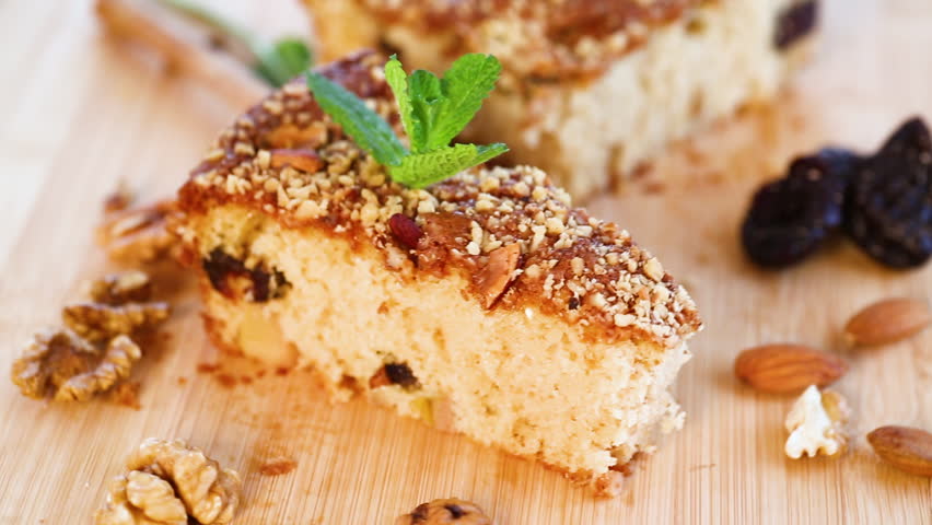 Sponge cake with prunes and nuts on wood