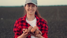 Woman gardener smiling, holding out ripe carrot harvest. Female farmer holding carrots in hands, field. Ripe vegetables, carrots. Concept of gardening using natural food. Growing organic food, harvest - Powered by Shutterstock - Get 15% off with code: PIKWIZARD15