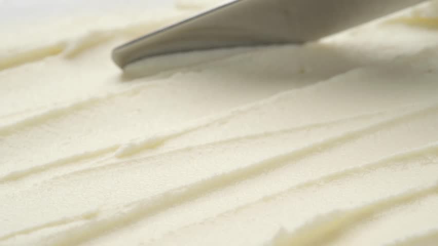 Close-up knife scooping natural cream cheese from package, concept video