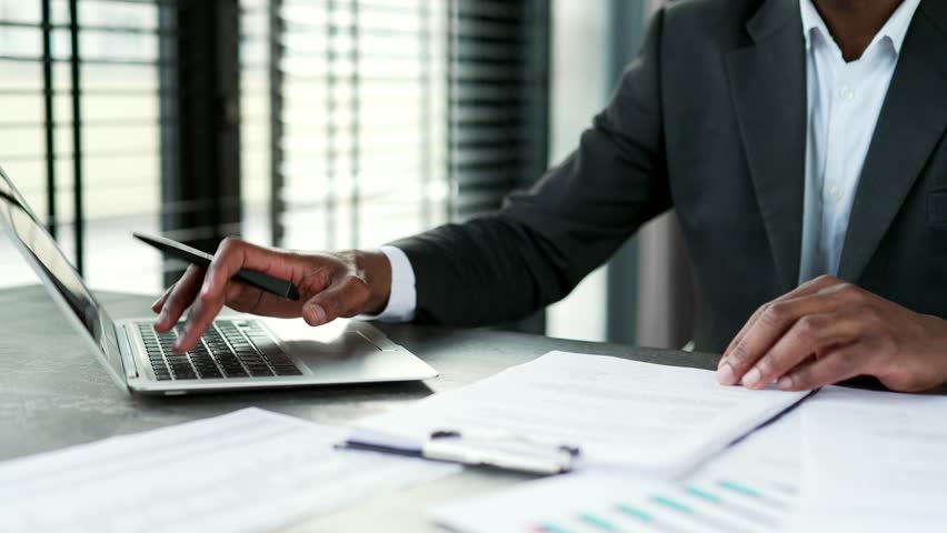 Close up of male hands typing on laptop keyboard in modern office. African american businessman works on a computer sitting at a workplace at a desk. Worker is engaged in parer work using technology - Powered by Shutterstock - Get 15% off with code: PIKWIZARD15