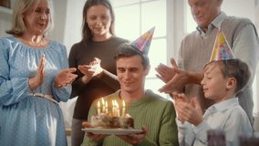 Portrait of middle-aged man celebrating birthday at home, family congratulating. Happy old parents, wife and child son cheering and rejoicing, family birthday party, people of three generation and age - Powered by Shutterstock - Get 15% off with code: PIKWIZARD15