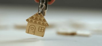 Apartment owner holding keys with a wooden keychain and shaking it after moving in real estate purchase new home. Slow-motion video - Powered by Shutterstock - Get 15% off with code: PIKWIZARD15